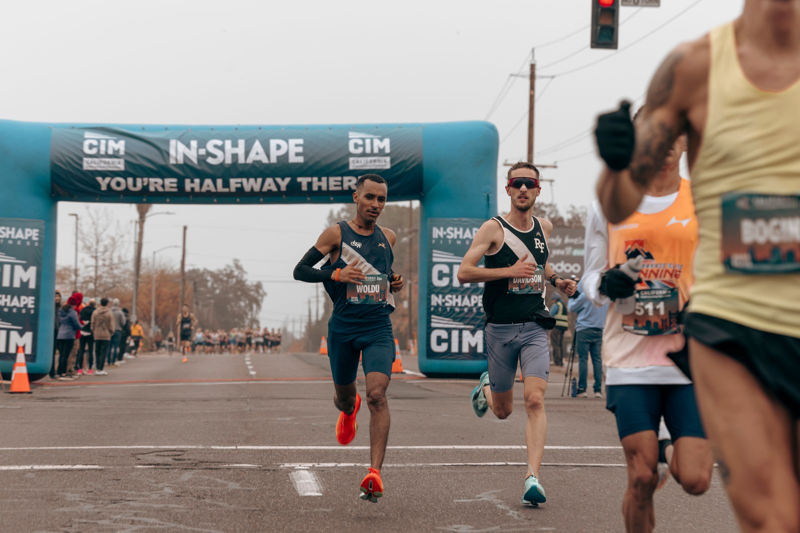 Runners under a half-marathon arch