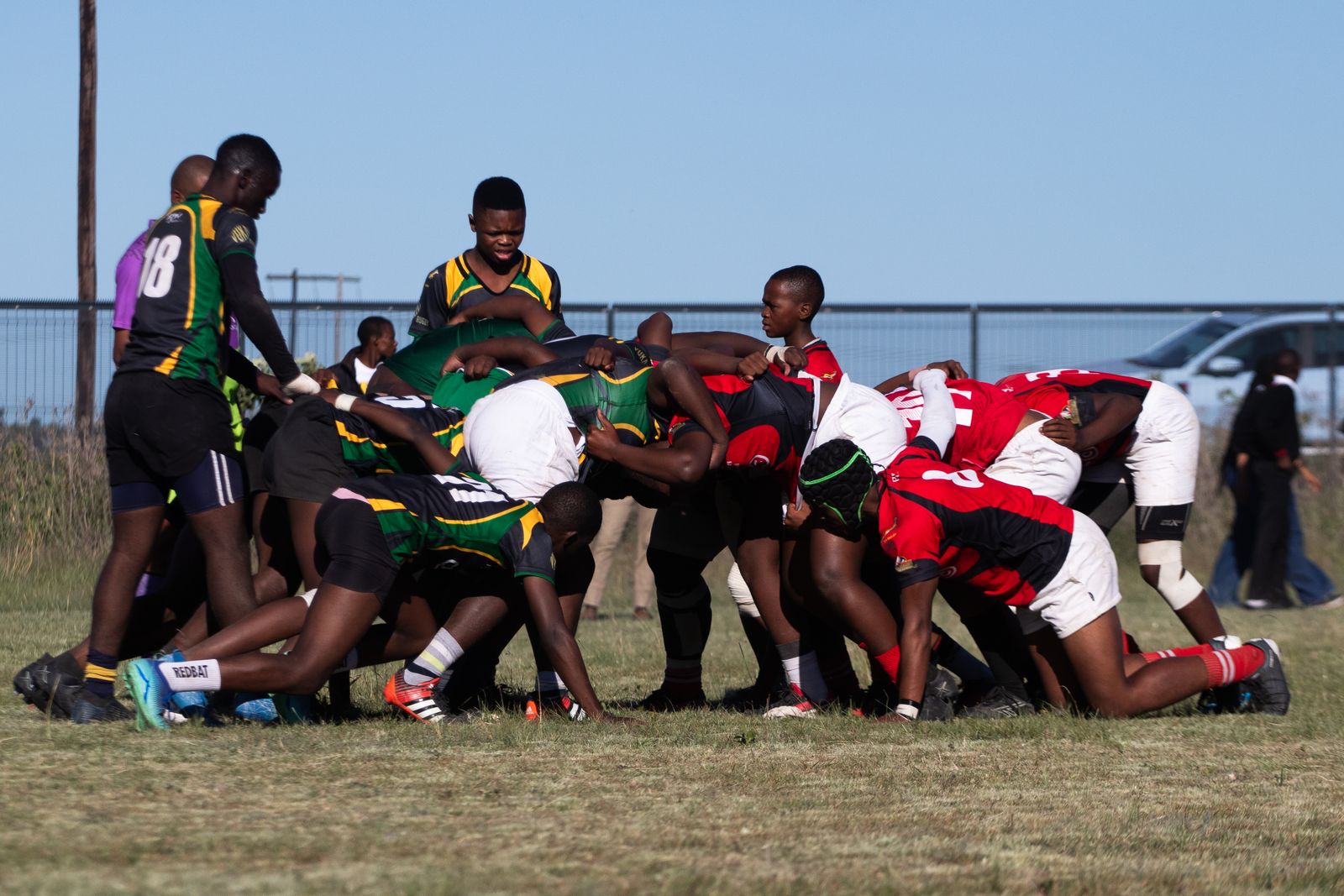 Schoolboy rugby scrum in hard winter sunlight