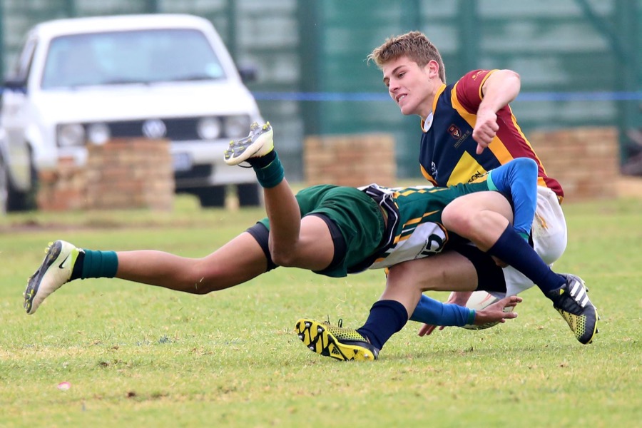 Junior rugby tackle on a dry field