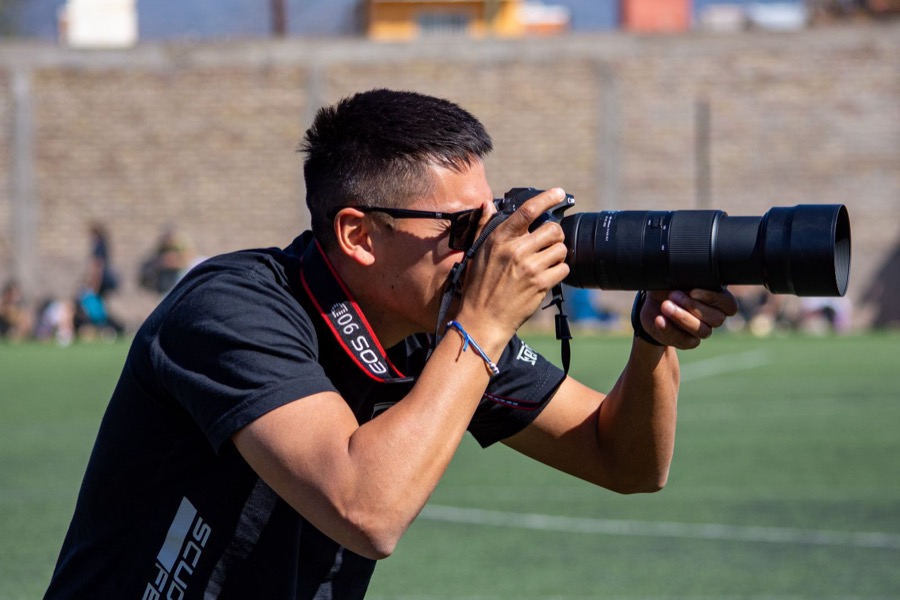 Sports photographer with a long lens on the touchline